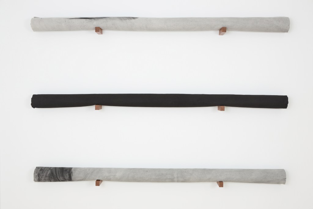 2º PREMIO ADQUISICIÓN Irene Grau  Sobre lo que resta, 2019  cenizas sobre lienzo enrollado en tubo de cartón y soporte de madera  134,5 x 200 x 13 cm